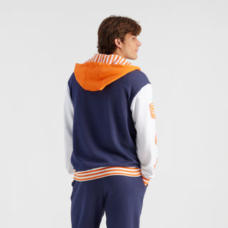 Person wearing a colorful tracksuit with an orange hood on a white background