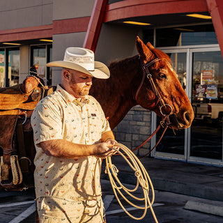 view man standing in front of horse wearing the texas burger shorts