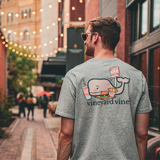 man wearing vineyard vines shirt in lively brick alleyway with string lights