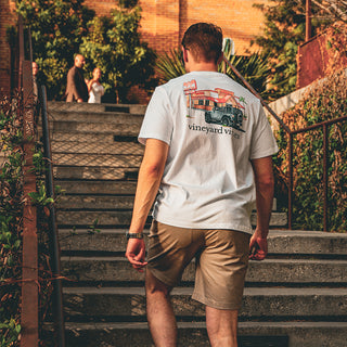 man wearing vineyard vines tee, walking up a set of stairs.