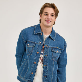 Model wearing the Wrangler® x Whataburger® Men's Laser Denim Jacket – The model smiles while wearing the denim jacket, styled casually over a white t-shirt.