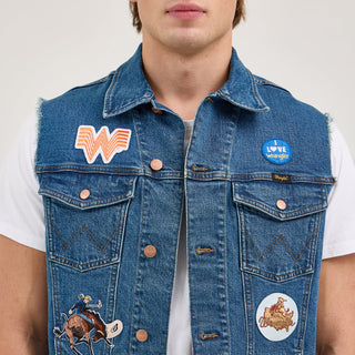 Full front view of the Wrangler® x Whataburger® Men's Cut-Off Vest – A male model wears the Wrangler® x Whataburger® Men's Cut-Off Vest, showcasing its embroidered patches, copper buttons, and classic denim details.