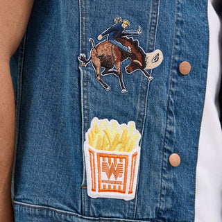 Lower front detail of the Wrangler® x Whataburger® Men's Cut-Off Vest – A close-up view of the Wrangler® x Whataburger® Men's Cut-Off Vest, highlighting a rodeo bull rider embroidered patch and a Whataburger® French fries patch near the bottom.