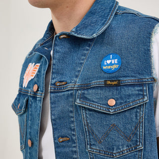 Side view of the Wrangler® x Whataburger® Men's Cut-Off Vest – A male model wears the Wrangler® x Whataburger® Men's Cut-Off Vest, featuring an "I Love Wrangler" patch above the chest pocket and additional Western-themed embroidered patches.