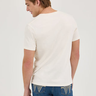 Back View: The back view of the Wrangler® x Whataburger® White Graphic T-Shirt, showing a clean, plain white fabric. The model is also wearing blue jeans with Wrangler’s signature W-stitched back pockets.