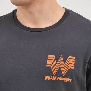 A detailed shot of the upper chest area of the T-shirt, focusing on the small orange Whataburger "W" logo with "WHAT A Wrangler" text beneath it. The ribbed neckline and soft texture of the fabric are visible.