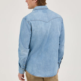 Back view of the Wrangler® x Whataburger® Men's Western Shirt – A male model stands with his back to the camera, showcasing the yoke detail and clean, light-wash denim design of the Wrangler® x Whataburger® Men's Western Shirt.