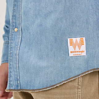 Close-up of the hem on the Wrangler® x Whataburger® Men's Western Shirt – A zoomed-in view of the lower portion of the shirt, showcasing a Whataburger® patch near the hem and a raw, frayed edge for a rugged finish.