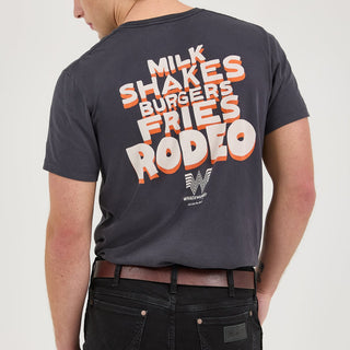 The model is turned around, showcasing the full back of the t-shirt. The bold typography of the phrase "MILK SHAKES BURGERS FRIES RODEO" stands out against the black fabric, with the Whataburger Flying W logo positioned below.