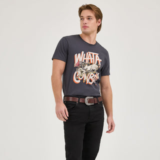 The model is fully visible, wearing the Wrangler® x Whataburger® Cowboy Graphic Black T-Shirt, black jeans, cowboy boots, and a brown belt. The casual, Western-inspired styling is emphasized.