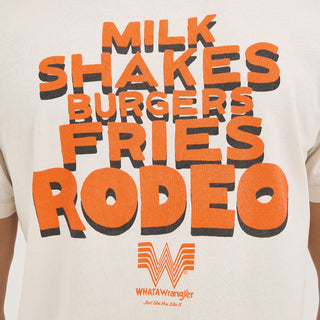 A close-up of the back design, showcasing the bold orange and black stacked text "MILK SHAKES BURGERS FRIES RODEO" and the Whataburger Flying W logo, screen-printed on the white fabric.