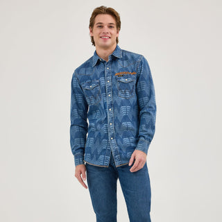 A male model wearing the Wrangler® x Whataburger® Men's Western Print Shirt – A male model wears the Wrangler® x Whataburger® Men's Western Print Shirt, styled with denim jeans. The shirt's Western-inspired design, including the snap buttons and bold pattern, is fully displayed.