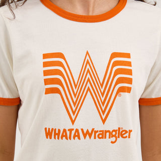 A detailed view of the front of the Wrangler® x Whataburger® Women's Ringer Tee, highlighting the bold Whataburger "W" logo and "WHATAWrangler" text in bright orange. The soft fabric and ribbed collar details are visible.