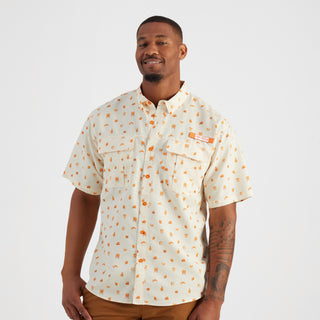 Man wearing a patterned shirt on a plain background