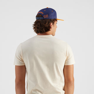 Person wearing a blue and orange cap on a white background