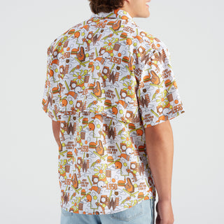 Person wearing a colorful patterned shirt with food-themed designs on a white background
