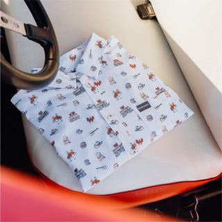Folded white button-up shirt with Whataburger icons on a car seat.