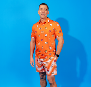 View man wearing Whataburger x Chubbies orange polo and striped swim trunks.
