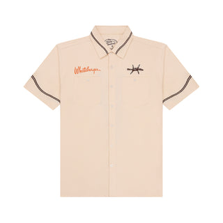 Beige shirt with embroidered designs on a white background