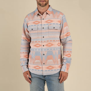 Man wearing a patterned shirt with a beige background