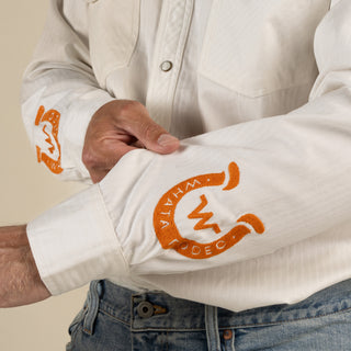 White jacket with orange logo on sleeve, worn by a person.