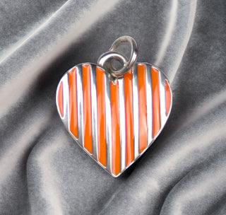 Front View Orange/Sterling Silver Striped Heart Charm on grey wavy velvet