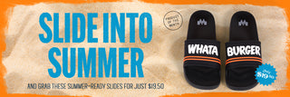Pair of black Whataburger slides with 'WHATA' and 'BURGER' printed on each sandal, displayed on sand with text promoting them as the product of the month for $19.50.