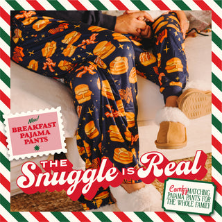 Person wearing pajama pants with breakfast-themed design, sitting on a couch.