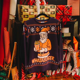 Christmas-themed sweater with Santa Claus holding a Whataburger sign, surrounded by holiday wrapping paper and ribbons.