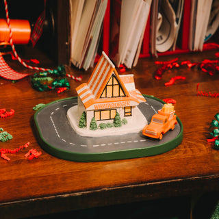 Model of a Whataburger restaurant with a toy truck on a wooden surface