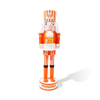 Whataburger nutcracker figurine in orange and white uniform with '75' on a white 75th Birthday Cake with light-up candles