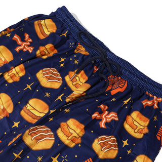 Navy blue pajama pants with Whataburger breakfast pattern on a white background