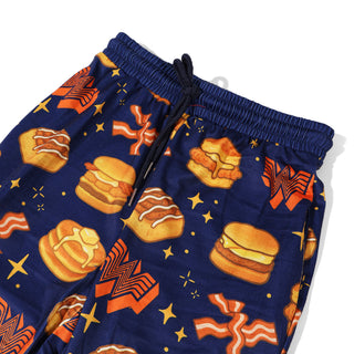 Navy blue youth pajama pants with Whataburger breakfast pattern on a white background