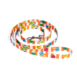A dog leash with a silver metal clasp, featuring a white and orange striped pattern with colorful day dot stickers, shown on a plain white background.