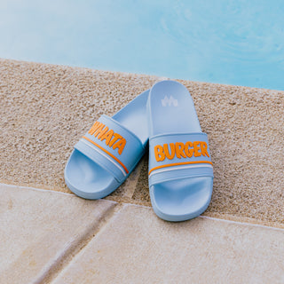 Light Blue Slides with orange Whataburger text sitting next to the pool
