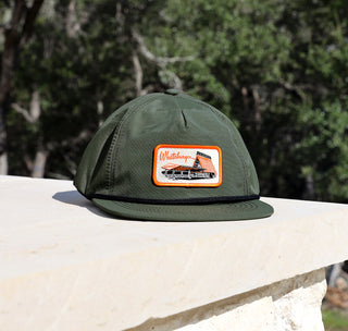 view retro a-frame nylon green hat on limestone with trees in the background.