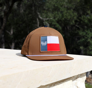 View Tan Texas Flag Staunch hat on limestone with trees in the background.