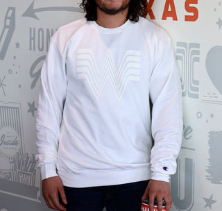 View man wearing a whataburger white flying w champion crewneck sweater leaning against a wall.