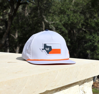 View white whataburger texas staunch hat on limestone with trees in the background.