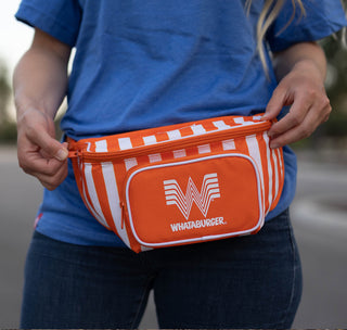 view woman in blue shirt and jeans wearing orange and white whataburger fanny pack